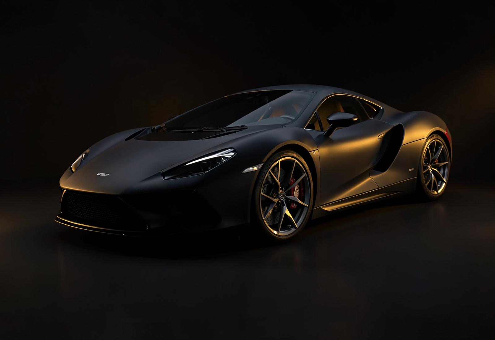 A sculptural sports car in a dark studio