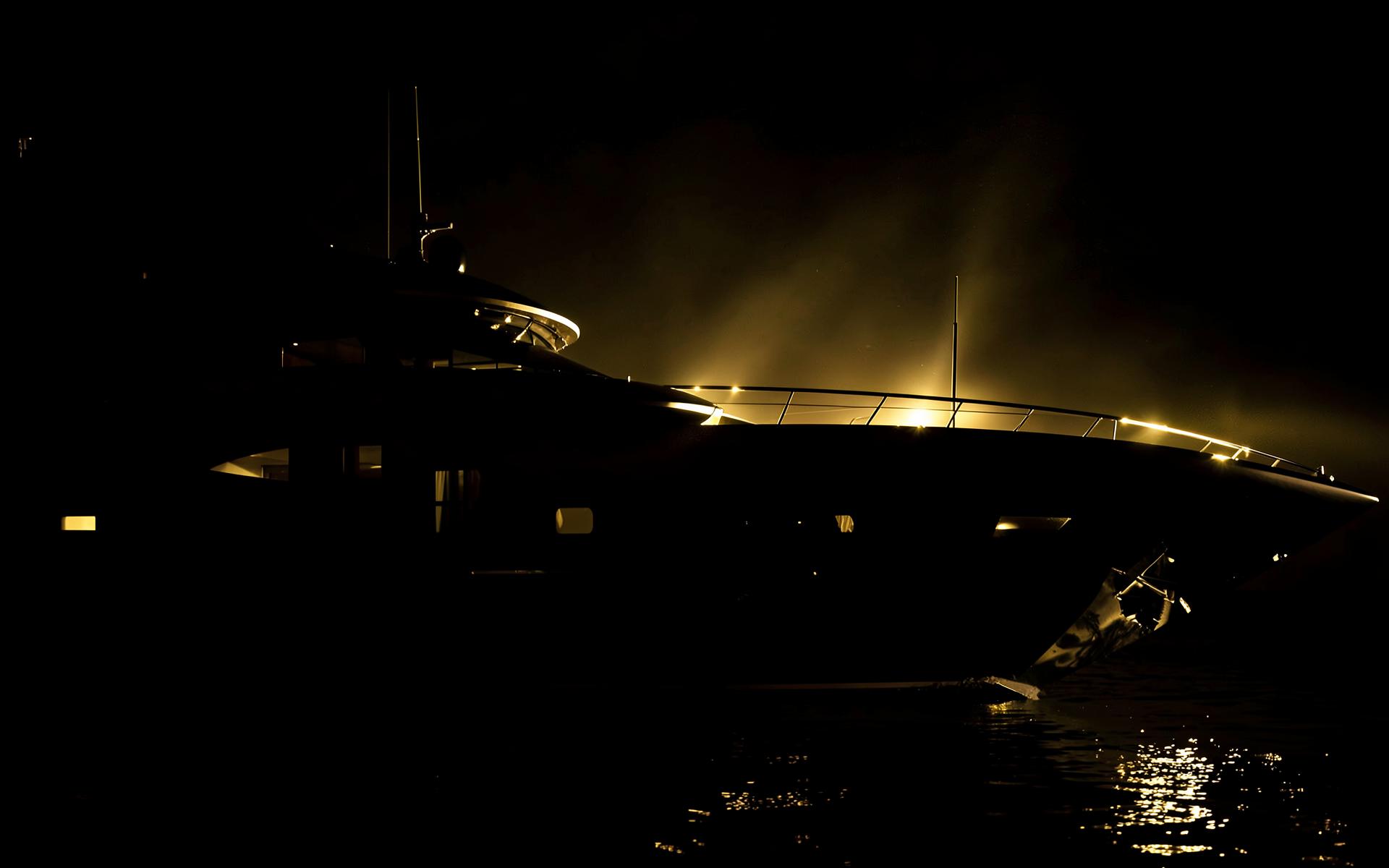 A yacht at night lit in warm gold